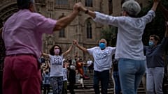 People wearing face masks to protect against COVID-19 perform a traditional Catalan dance in Barcelona, Spain, on June 5, 2021.