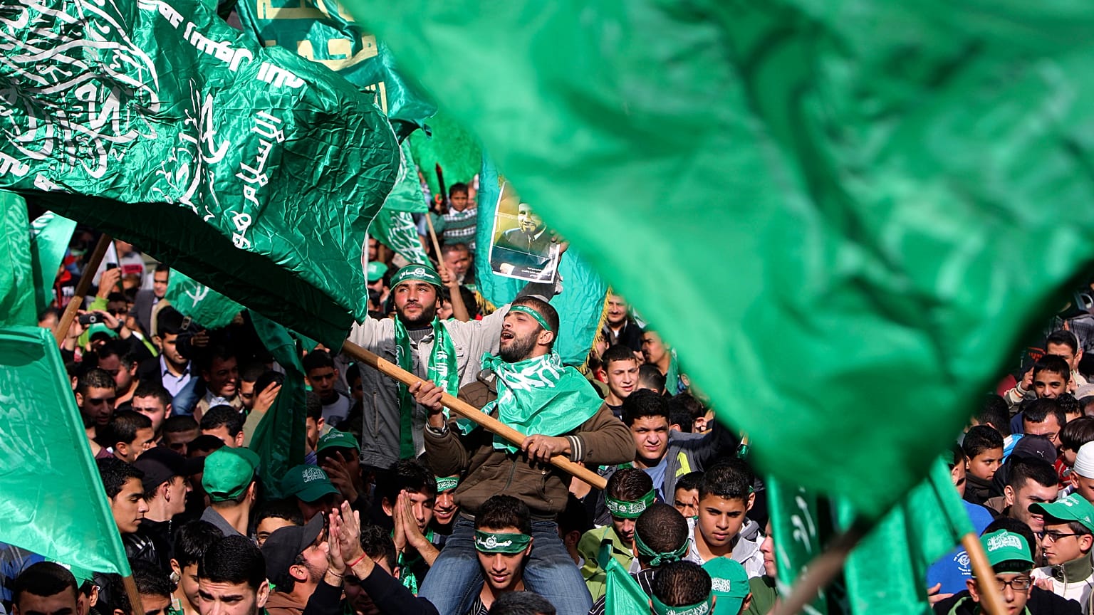متظاهر فلسطيني يلوح بعلم حركة المقاومة الإسلامية (حماس)  