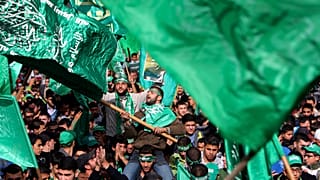 متظاهر فلسطيني يلوح بعلم حركة المقاومة الإسلامية (حماس)