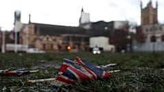 A British Union flag from Brexit day celebrations lies in the grass in front of the Palace of Westminster in London, early Saturday, Feb. 1, 2020.