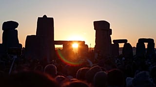 The sun rises over the ancient stone circle in Wiltshire, England on the summer solstice in 2019.