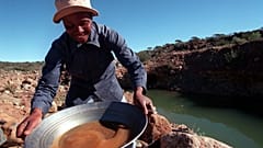 منقب للماس يغسل الحصى الذي أخذه من مجرى يمر عبر منجم نوبل دايموند في روستنبرج، جنوب إفريقيا. 