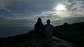 Una pareja disfrutando del atardecer en Fisterra, Galicia, España, el 21 de junio de 2021.