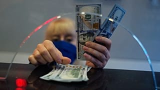 Bir kadın döviz bürosunda ABD doları banknotlarını sayıyor, Ankara, 22 Mart 2021.