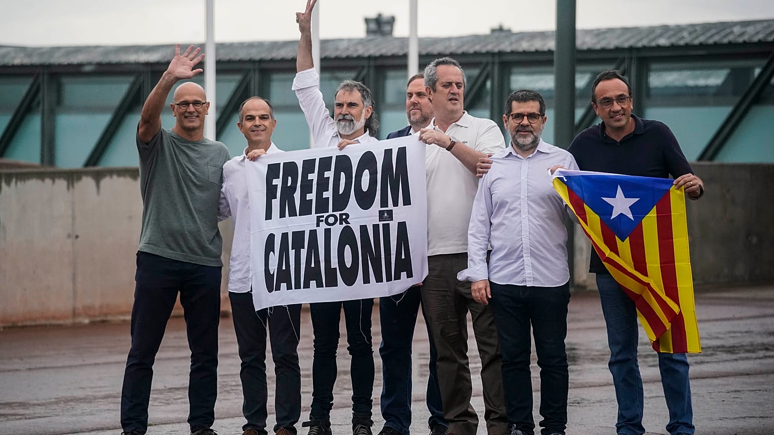 Catalan leaders hold a banner and Catalan pro-independence flag outside Lledoners prison in Sant Joan de Vilatorrada, near Barcelona