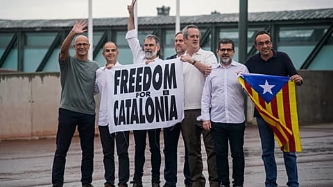 Catalan leaders hold a banner and Catalan pro-independence flag outside Lledoners prison in Sant Joan de Vilatorrada, near Barcelona