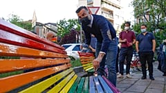 FILE - In this Friday, May 7, 2021 filer, Italian lawmaker Alessandro Zan paints a bench in the colors of the rainbow, in Milan, Italy. 