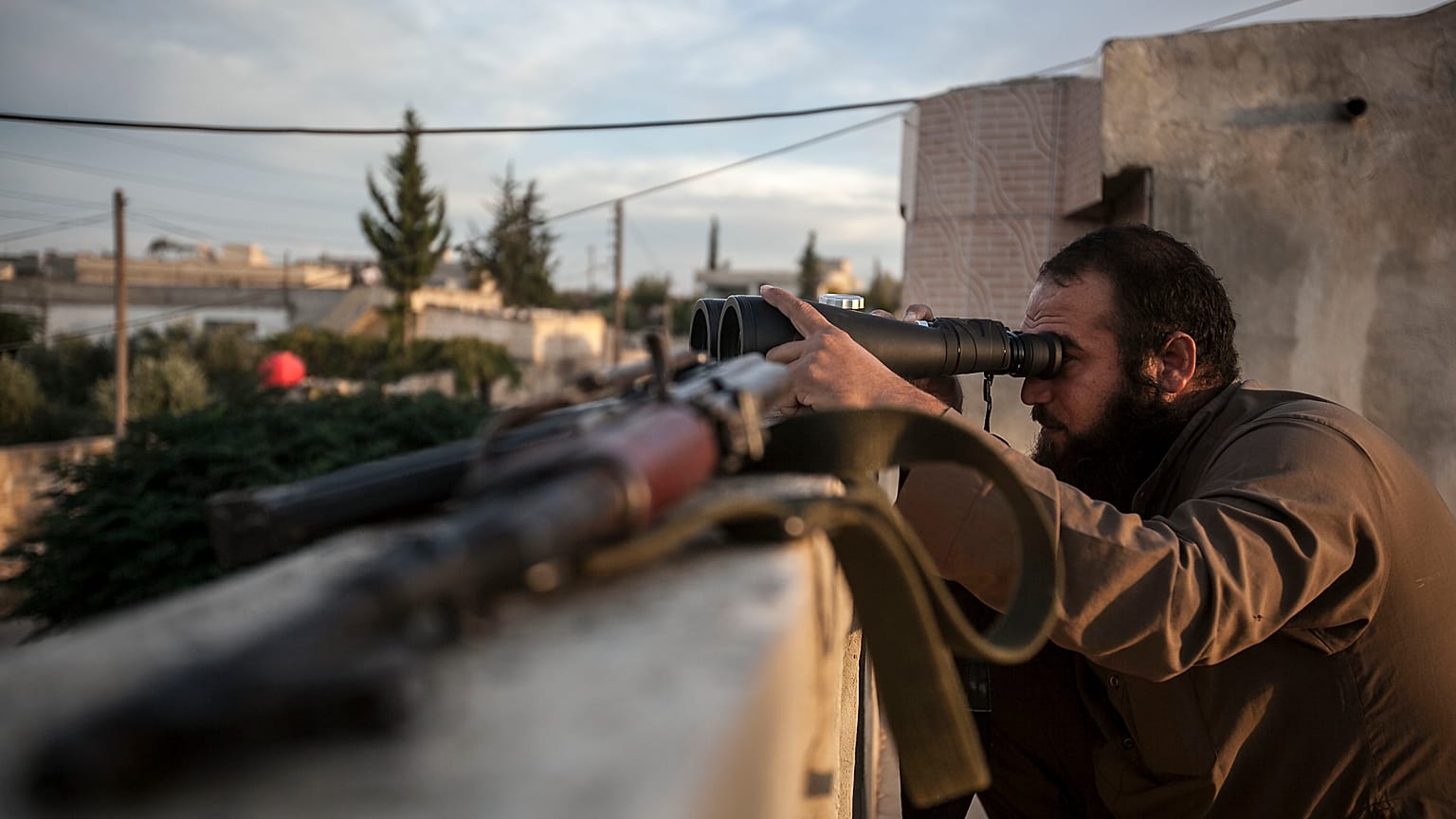 FILE: In this Thursday, Sept. 19, 2013 photo, a Syrian opposition fighter watches over as heavy fighting breaks out in in the Idlib province countryside, Syria