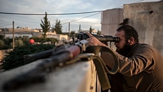 FILE: In this Thursday, Sept. 19, 2013 photo, a Syrian opposition fighter watches over as heavy fighting breaks out in in the Idlib province countryside, Syria