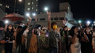 Supporters wave flashlights outside the Apple Daily headquarters in Hong Kong, Wednesday, June 23, 2021.