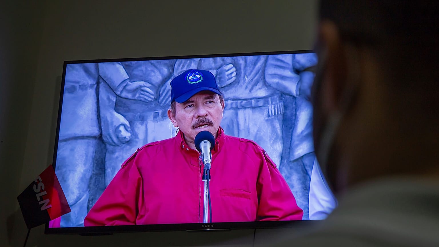 Un hombre sigue el discurso televisado del presidente de Nicaragua, Daniel Ortega, en su casa de Managua