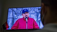 Un hombre sigue el discurso televisado del presidente de Nicaragua, Daniel Ortega, en su casa de Managua