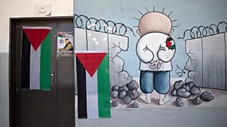 معلقة كاريكاتور للطفل الفلسطيني محمد حمايل توشح باب قسم مدرسي من بلدة بيتا في الضفة الغربية المحتلة. 