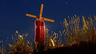 Archives : une robe d'enfant sur une croix dressée non loin du lieu où avait été découvert les restes de 215 enfants dans une fosse commune à Kamloops au Canada, le 6/6/2021