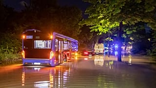 A bus is pictured stuck in water on a flooded road in Munich on Wednesday night.