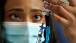 A licensed practical nurse draws a Moderna COVID-19 vaccine into a syringe at a mass vaccination clinic in Massachusetts, U.S. on May 19, 2021