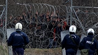 سياج حدودي يفصل بين الشرطة اليونانيين ومهاجرين يحاولون دخول اليونان من تركيا على الحدود في كاستاني. 2020/03/04