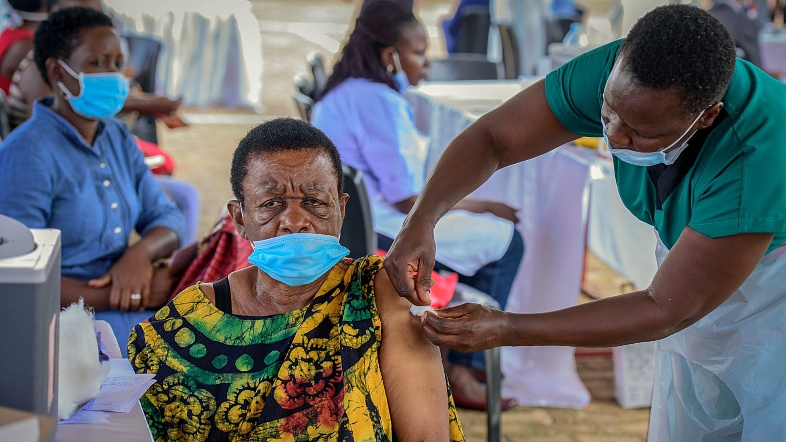 A woman receives a coronavirus vaccination at the Kololo airstrip in Kampala, Uganda.