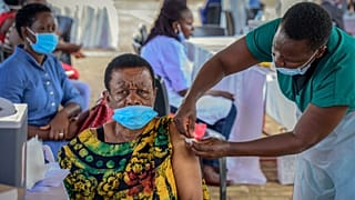 A woman receives a coronavirus vaccination at the Kololo airstrip in Kampala, Uganda.