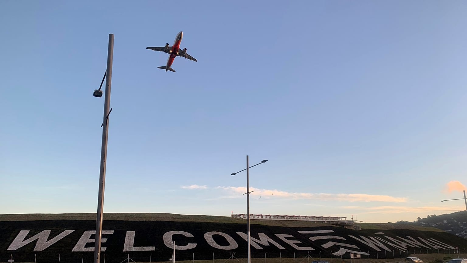 A giant sign painted near the main runway of the Wellington International Airport greets travellers returning home on April 19, 2021.