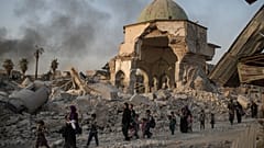 Fleeing Iraqi civilians walk past the damaged al-Nuri mosque as Iraqi forces continue their advance against IS militants in the Old City of Mosul, Iraq, July 4, 2017.