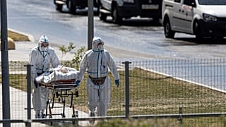 Medical workers carry a patient suspected of having coronavirus on a stretcher at a hospital in Kommunarka, outside Moscow