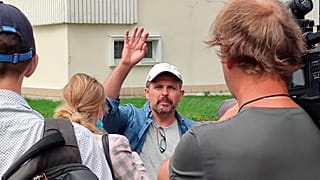 Roman Badanin, chief editor of the Proekt investigative online outlet, waves journalists as he departing to police station in Moscow, Russia, Tuesday, June 29, 2021.