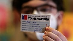 Un joven sujeta un carnet de la campaña Yo Me Vacuno