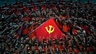 Performers gather around a Communist Party flag during a gala ahead of the 100th anniversary of the founding of the Chinese Communist Party in Beijing on June 28, 2021.
