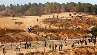 فلسطينيون في الخليل بالقرب من الجدار الإسرائيلي، الضفة الغربية.