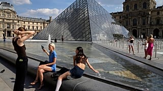 Fransa'nın başkenti Paris'in en fazla ziyaret edilen mekanlarından olan Louvre Müzesi yerleşkesinde fotoğraf çektiren turistler