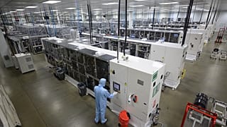 Nissan employees make final checks to cars on the production line at Nissan's plant in Sunderland, north east England on July 1, 2021. 