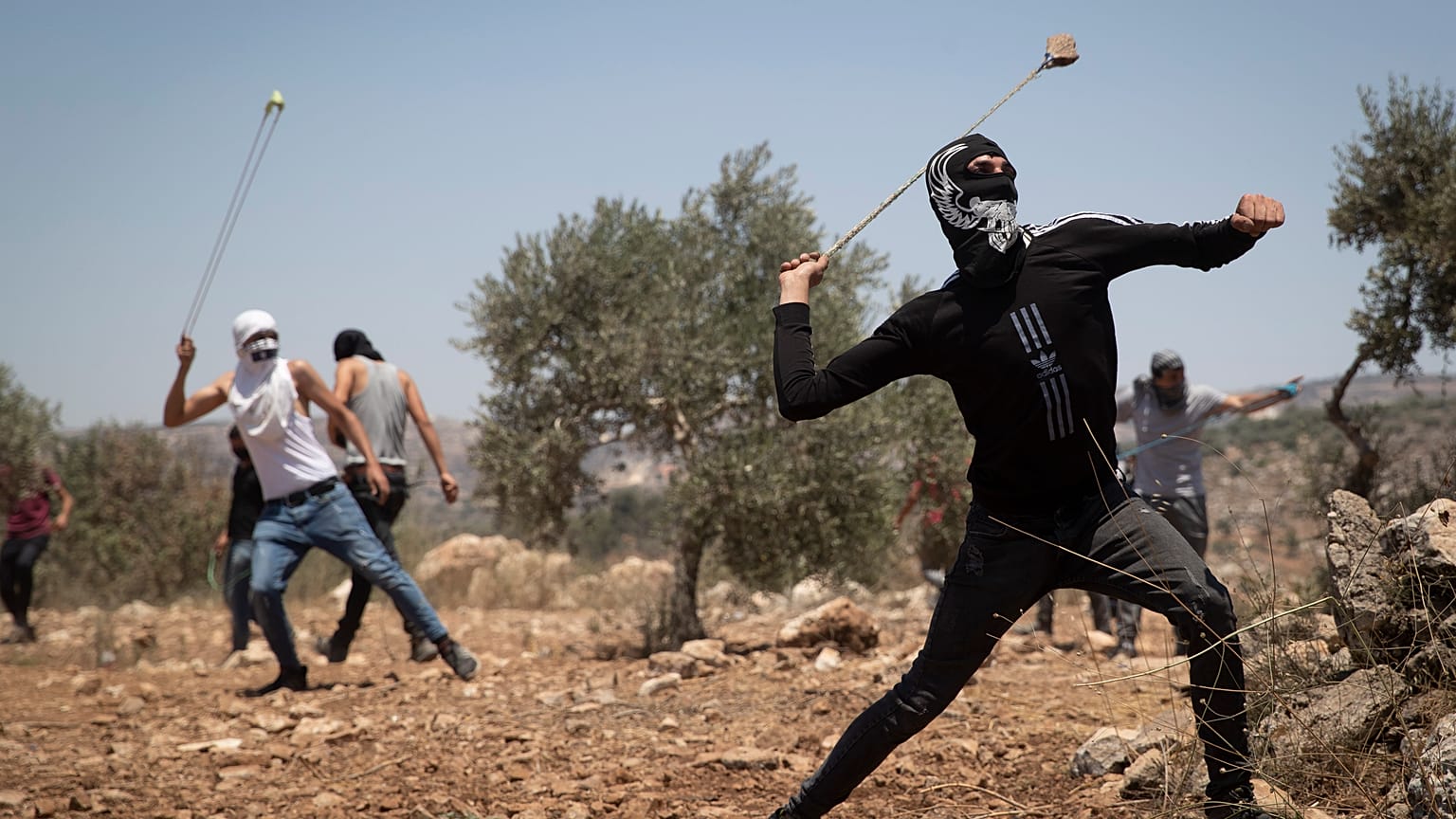 فلسطينيون يستخدمون المقلاع لرشق الحجارة خلال احتجاج على البؤرة الاستيطانية التي أقيمت في قرية بيتا الفلسطينية. 