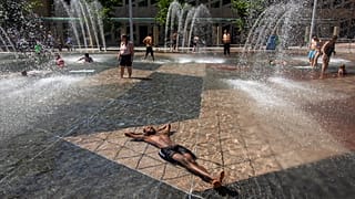 Aki teheti, a szökőkútban fekszik a hőség idején, EDMONTON, AB, CANADA