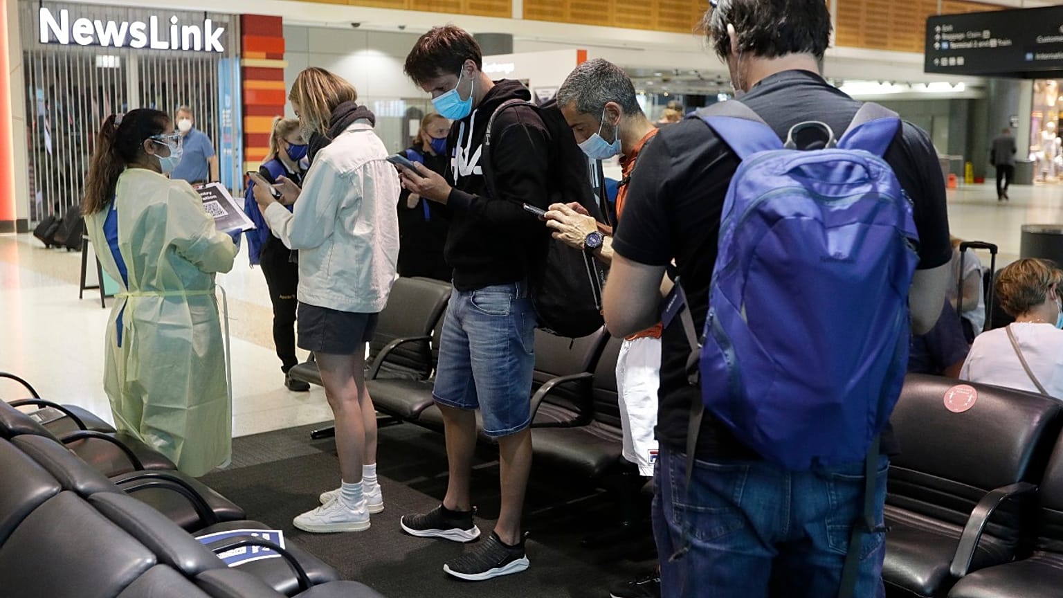 Passengers arriving from Melbourne are screened by health workers at the airport in Sydney, Australia, Friday, Feb. 12, 2021.
