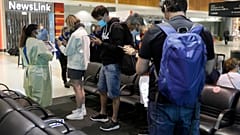 Passengers arriving from Melbourne are screened by health workers at the airport in Sydney, Australia, Friday, Feb. 12, 2021.