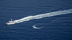 An overcrowded migrant boat, bottom, tries to escape from the Libyan Coast Guard in the Mediterranean, June 30, 2021. Sea-Watch is denouncing both Libya and the EU.