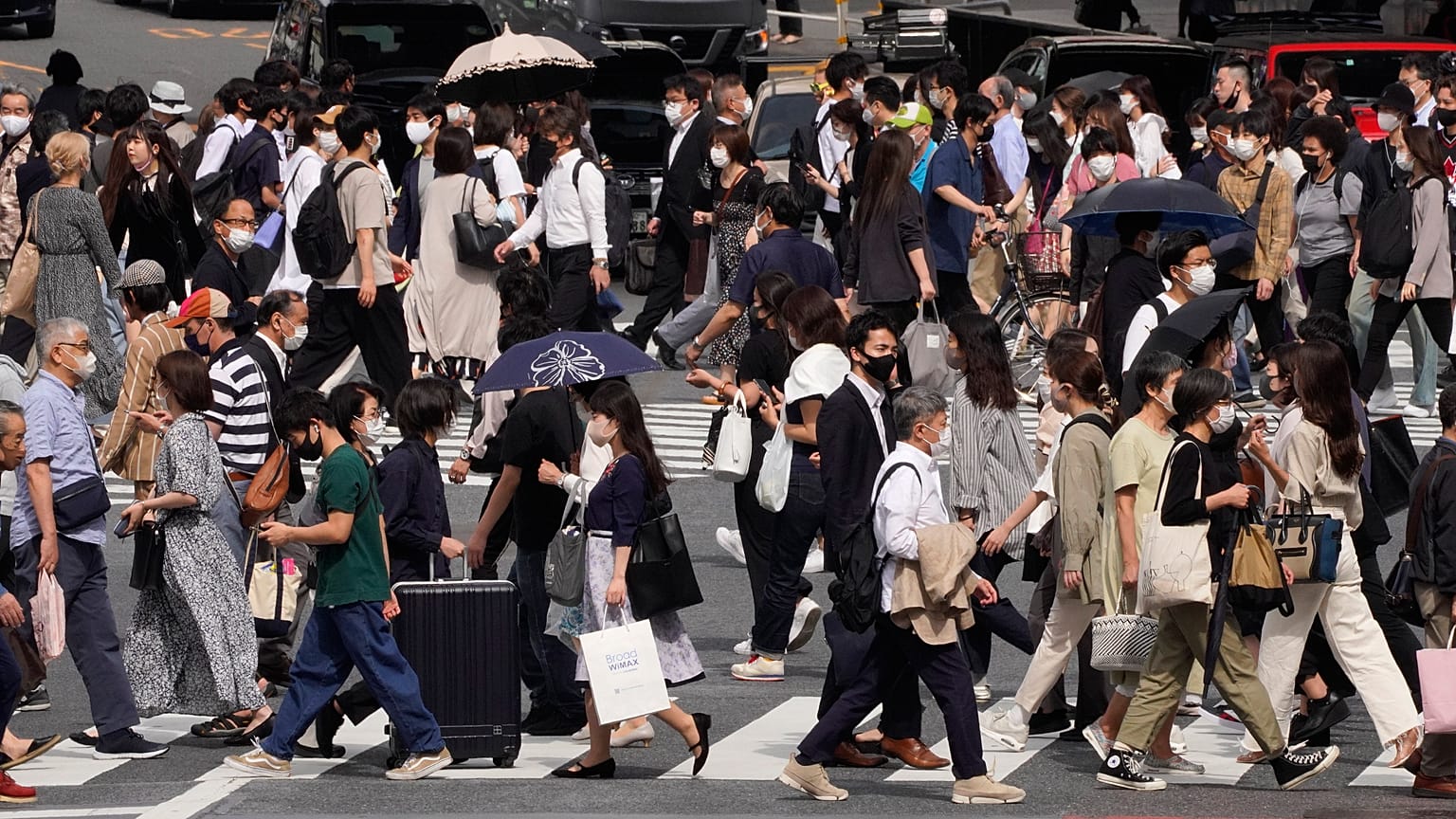 Védőmaszkos gyalogosok a japán főváros Sibuja negyedében