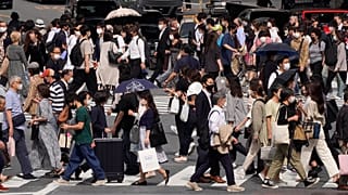 Védőmaszkos gyalogosok a japán főváros Sibuja negyedében