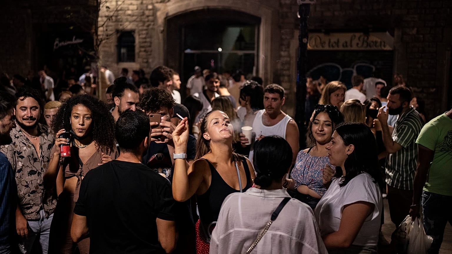 Un grupo de jóvenes está de fiesta nocturna en una concurrida calle de Barcelona.