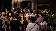Un grupo de jóvenes está de fiesta nocturna en una concurrida calle de Barcelona.