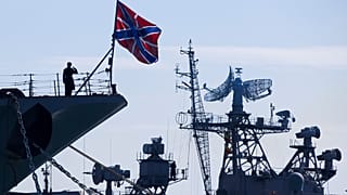 FILE: A Russian sailor salutes on the bow of Missile Cruiser Moskva, left, in Sevastopol, Crimea, Sunday, March 30, 2014. 