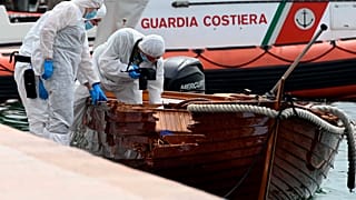 Italian forensic police inspect the damage on the couple's boat.