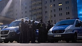 Federal German police forces stand in a parking lot in Berlin-Lichtenberg and prepare for a raid.