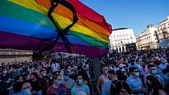 A rainbow flag with a black ribbon flutters during a protest on Monday in the Puerta del Sol in central Madrid.