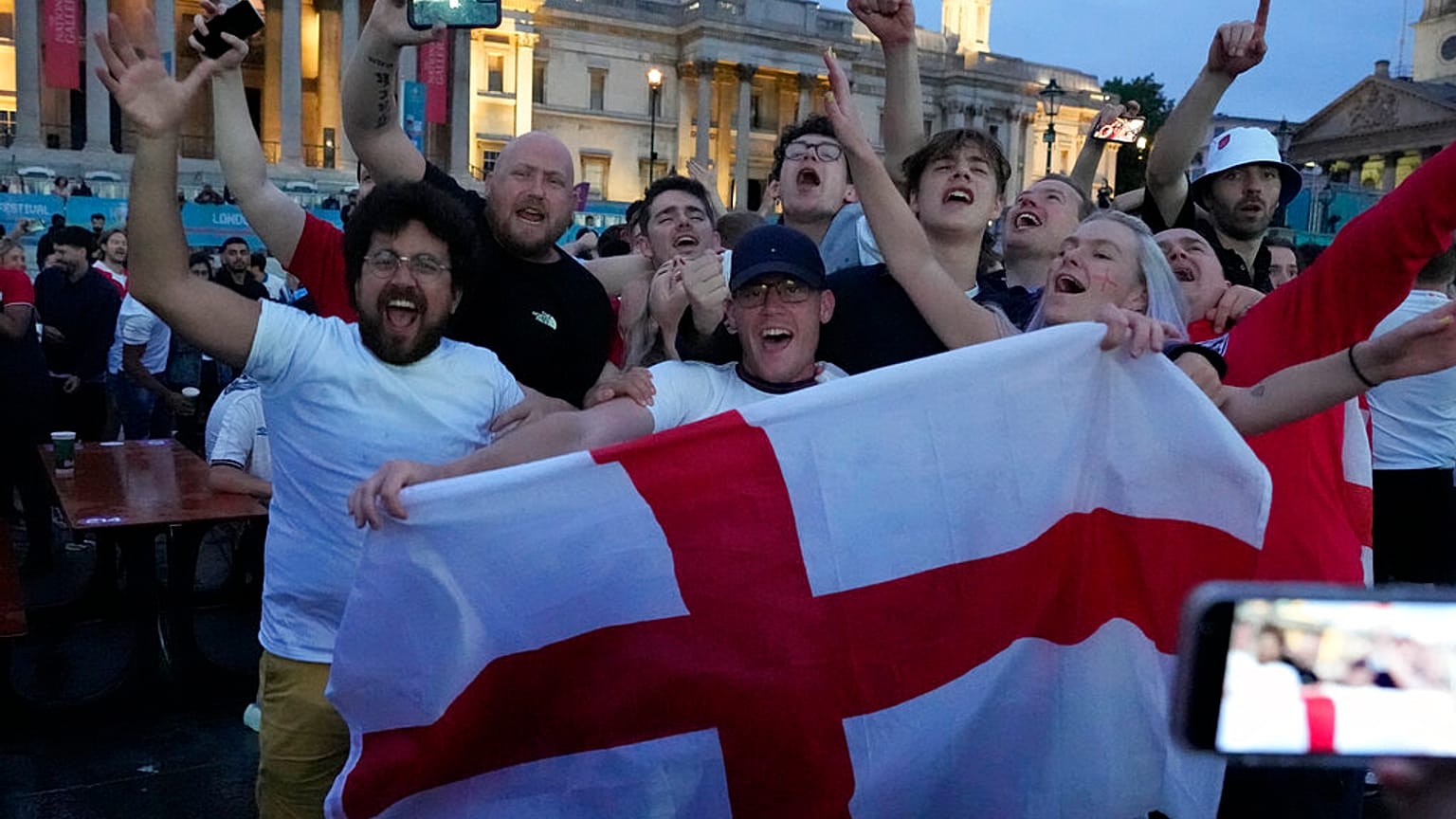 İngiltere'nin başkenti Londra'nın Trafalgar Meydanı'nda sevinç gösterileri yapan futbolseverler. Dikkat çeken ayrıntı, hiçbirinin maske takmaması.