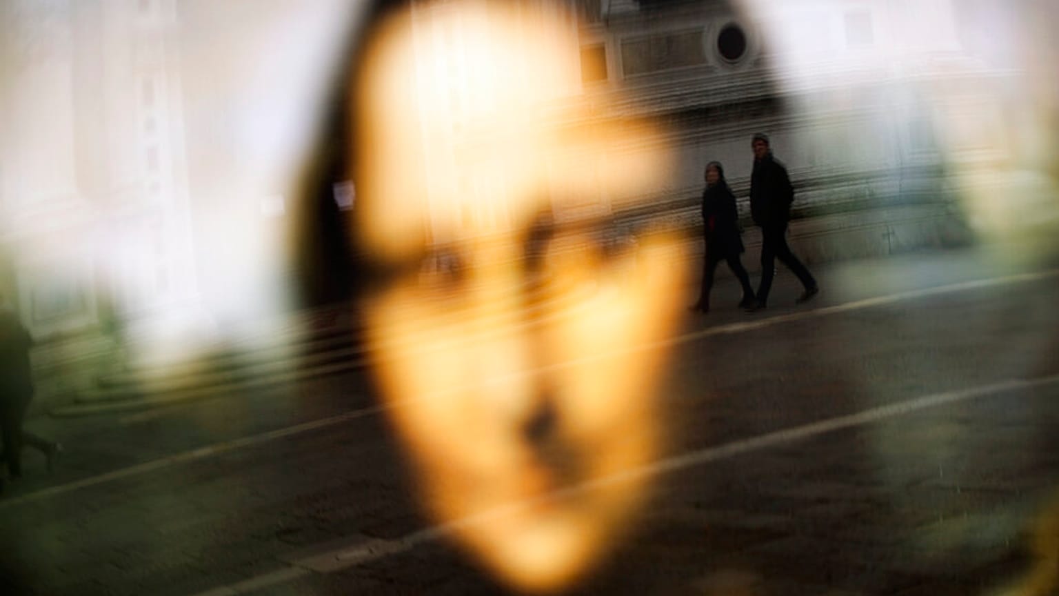 Da Vinci leghíresebb alkotása, a Mona Lisa plakátja előtt sétáló emberek