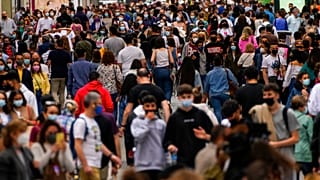 FILE: In this June 5, 2021, file photo, people wearing face masks to protect against the spread of coronavirus, walk along a commercial street in downtown Madrid, Spain