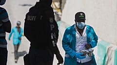 Um investigador da polícia do Haiti com um saco cheio de balas recolhidas no palácio presidencial