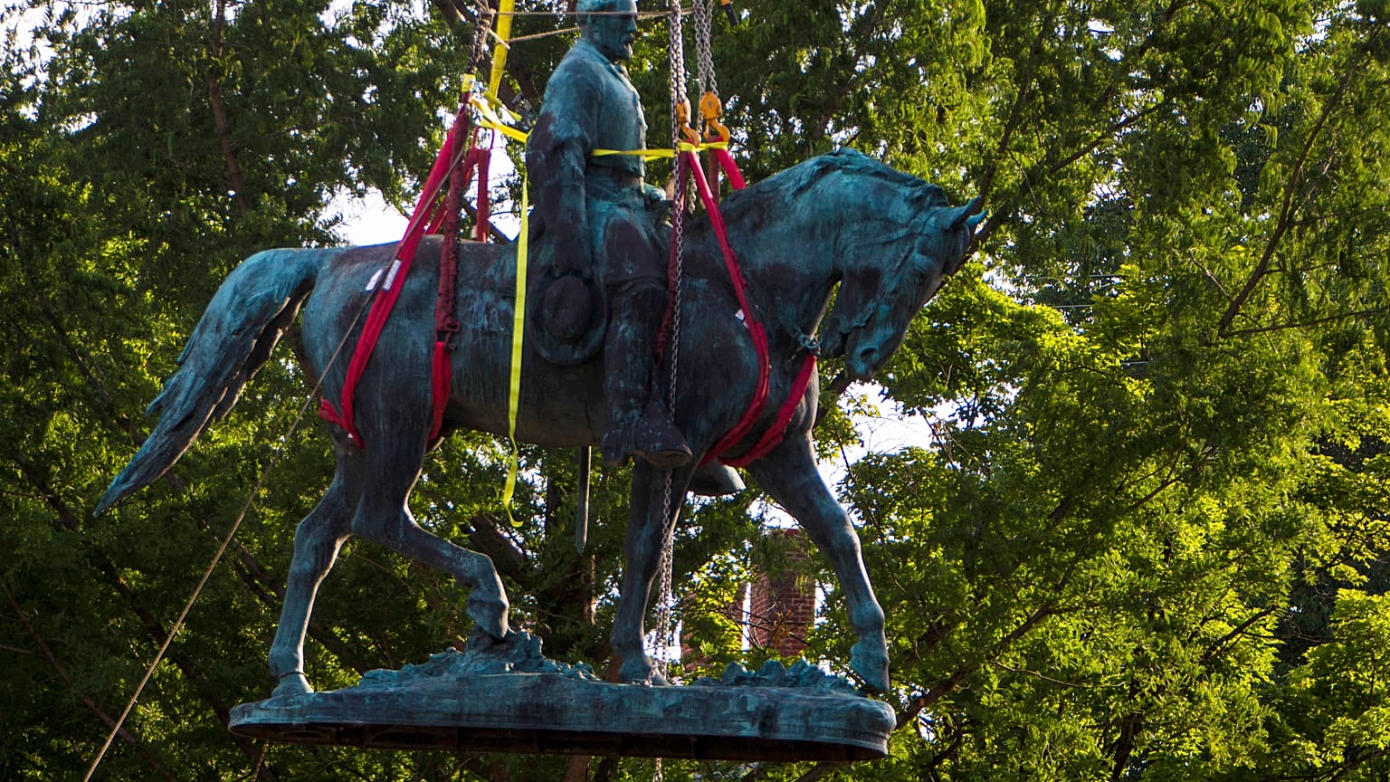 Workers remove the monument of Confederate General Robert E. Lee on Saturday, July 10, 2021 in Charlottesville, Va. 